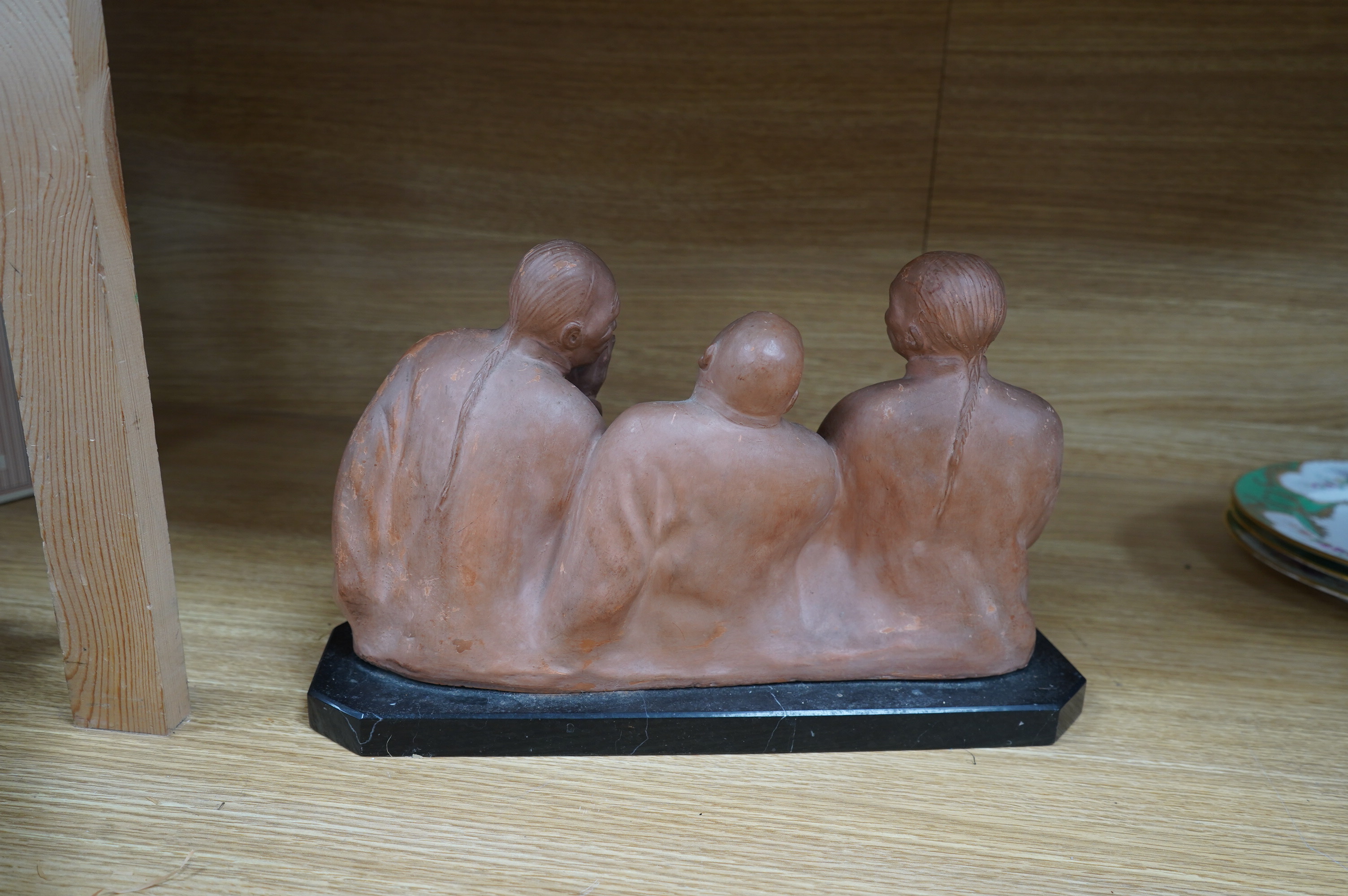 A French Art Deco terracotta sculpture of three seated Asian gentlemen, signature near base, 35cm high. Condition - fair